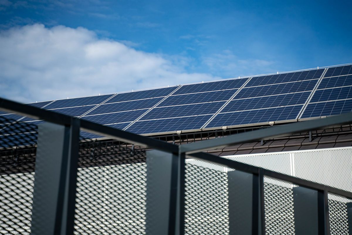 Technician fitting mounting rails for roof-mounted solar panels